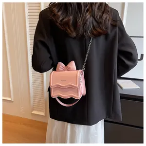 Close-up of pink leather handbag featuring a stylish 3D bow and silver logo detail