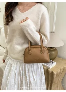 Detail of caramel lychee grain leather handbag with enjoy each day embossed text