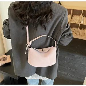 Detail view of the pink crescent baguette bag back with adjustable shoulder strap