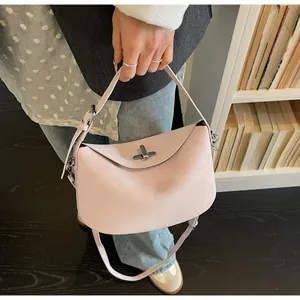 Detail of light pink baguette bag showing metallic swivel clasp and smooth faux leather