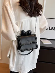 Minimalist black crossbody bag with bow decoration and silver metal chain strap