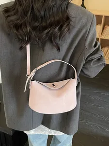 Minimalist light pink half-moon baguette bag with top handle and shoulder strap