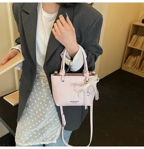 Dettagli della borsa a secchiello rosa con fiocco in pizzo, perle e ciondolo a cuore