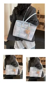 Detalle del bolso tote de gran capacidad con textura abstracta azul y colgante de osito