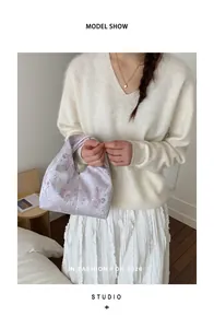 Gros plan sur un sac à main en satin lilas avec des motifs floraux élégants pour femmes