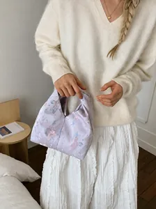 Sac à main en satin lilas à fleurs associé à une élégante jupe longue plissée blanche