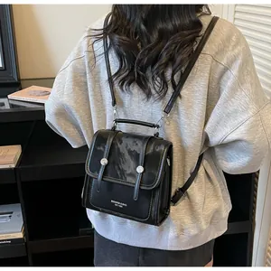 Close-up of black PU leather mini backpack with dual straps and metal buckle detailing