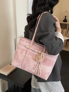Bolso tote rosa grande con motivos abstractos y colgante de oso en una modelo mujer