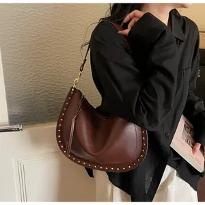 Detail view of vintage dark brown crescent tote bag featuring stylish gold rivet accents