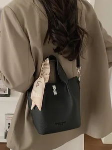 Chic black litchi pattern bucket bag with silk scarf on handle for modern women