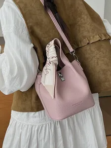 Pink lychee grain leather bucket bag with top handle and decorative silk scarf accessory