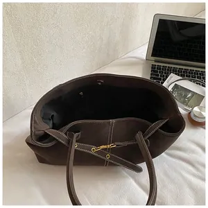 Détail du sac fourre-tout marron vintage avec surpiqûres blanches et grande capacité d'accueil