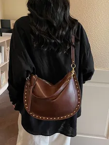 Brown leather hobo tote bag with gold stud trim shown from a stylish back view