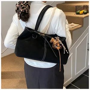 Détail du sac cabas noir mat avec coutures contrastées et pendentif nœud léopard