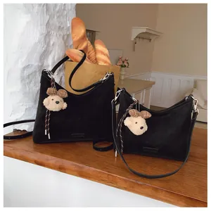 Detail von zwei schwarzen Vintage-Tote-Bags mit Bärenanhänger in Lifestyle-Szenerie
