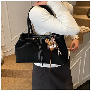 Détail du sac cabas en daim noir avec surpiqûres blanches et glands à motif léopard
