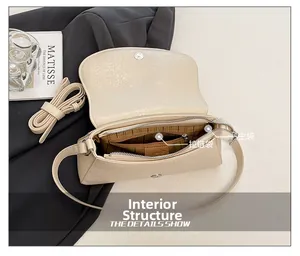 Interior detail of beige glossy crossbody bag showing zip pocket and main compartment