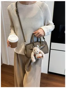 Khaki Leder Umhängetasche mit silbernem Drehverschluss und Plüschhasen-Anhänger