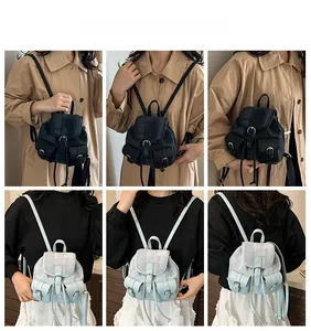 Detail view of mini plaid backpacks in dark grey and light blue with front pockets