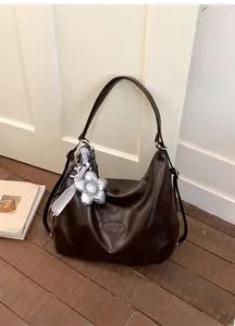 Detail der kaffeebraunen Hobo-Tasche aus PU-Leder mit großem silbernem Blumen-Anhänger