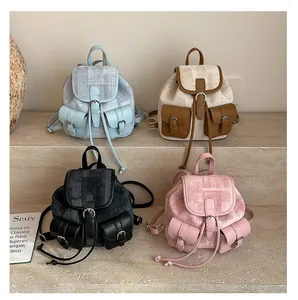 Detail of four mini tweed backpacks with leather trim in blue, brown, black and pink