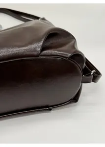 Nahaufnahme des verstärkten Bodens und der Lederstruktur einer dunkelbraunen Tote Bag