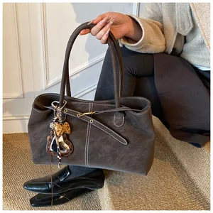 Détail du sac cabas mat vintage avec coutures contrastées et breloque cœur léopard