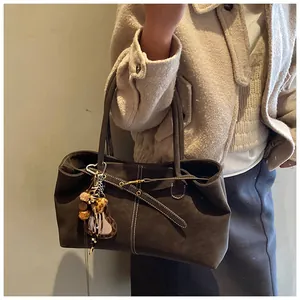 Détail du grand sac cabas marron foncé avec surpiqûres blanches et pendentif léopard