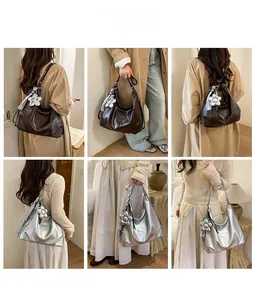 Detailansicht der Hobo-Tasche in Braun und Silber mit Blumenanhänger und Seidenschal