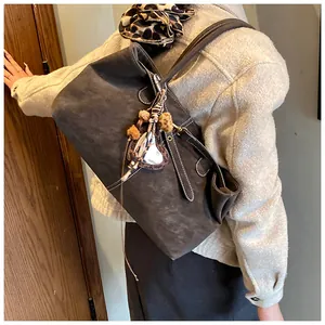 Détail du cabas mat marron foncé avec coutures blanches et breloque cœur léopard