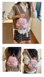 Detailed view of a mini pink fabric backpack featuring drawstring closure and side pockets