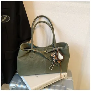 Détail du sac cabas vert olive en cuir grainé avec un miroir en forme de cœur attaché