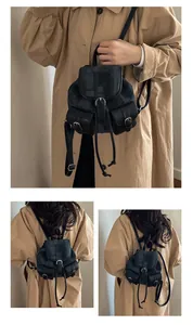 Detail view of retro canvas and leather backpack showing the front pockets and buckles