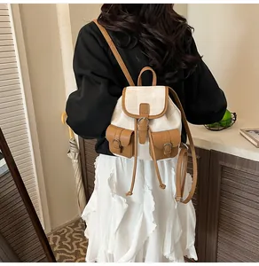 Detail showing the adjustable straps and vintage canvas texture of the beige backpack