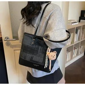 Detailed shoulder view of the two-tone tote bag with a cute plush bear pendant accessory