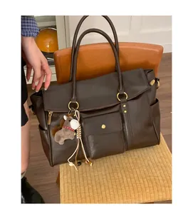 Détail d'un grand sac cabas vintage marron avec bijou de sac poney en peluche marron