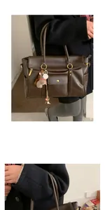 Détails d'un sac cabas marron foncé en simili cuir rétro avec fermetures éclair et pendentif