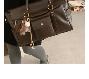 Détail du grand sac cabas marron vintage avec poches et pendentif cheval en peluche