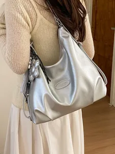 Große Tragetasche in Metallic-Silber an Model in einem minimalistischen Raum