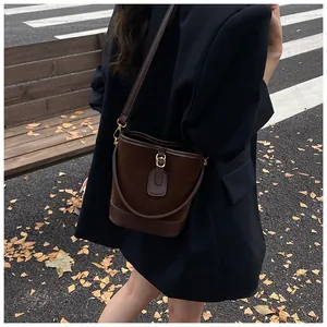 Detailansicht der dunkelbraunen Beuteltasche mit mattem Finish und Goldbeschlägen