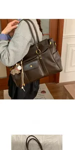 Détail du sac cabas marron vintage avec boucles dorées et breloque cheval