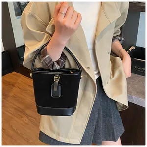 Detail der schwarzen Beuteltasche mit Wildleder-Glattleder-Mix und goldener Schnalle