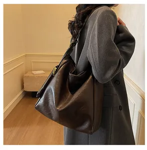 Detail view of large dark coffee tote bag with side zipper on grey wool coat