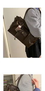 Détail du grand sac cabas en cuir mat marron foncé avec un charm ours en peluche