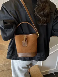 Vintage-Eimertasche aus braunem Wildleder mit Lederakzenten und Goldbeschlägen