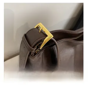 Detail of brown faux leather tote with adjustable shoulder strap and gold hardware