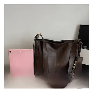 Detail view of brown leather tote bag with gold buckle and mini triangle coin purse