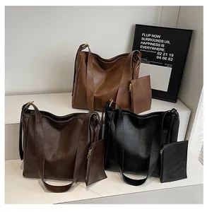 Three leather tote bags in black, deep brown and caramel brown with small coin purses