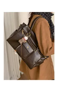Détail du sac cabas moto marron vintage avec fermetures éclair et pendentif en peluche