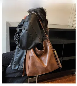 Detailed back view of a large brown vintage leather tote bag shown on a model